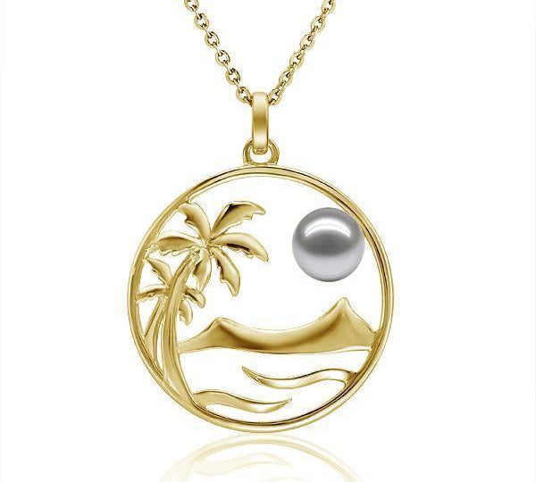 In this photo there is a yellow gold circle pendant with palm trees, diamond head mountain view, ocean waves, and one white/light gray Akoya pearl. 