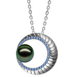 In this photo there is a white gold moon pendant with sapphires and a dark green pearl.