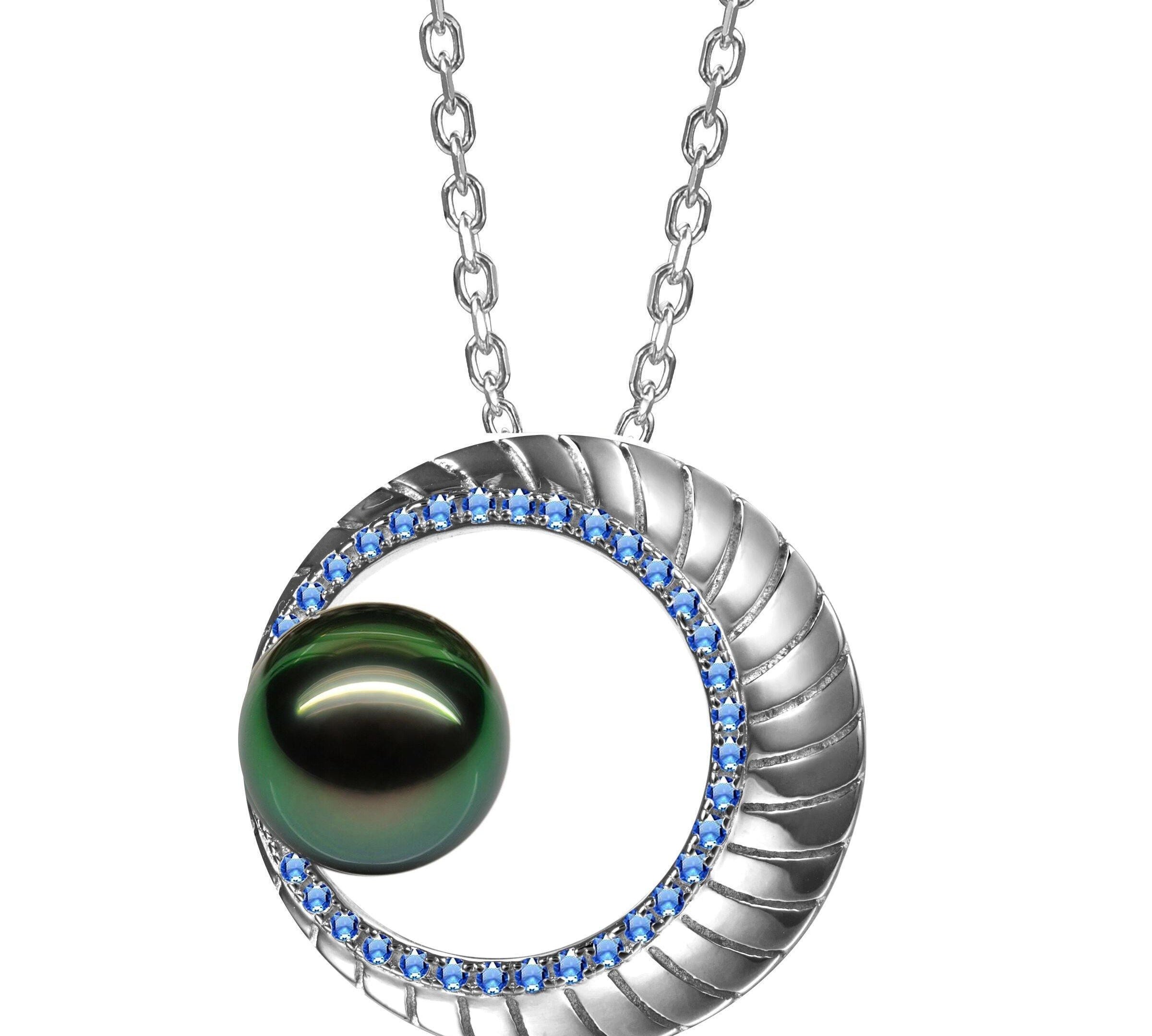 In this photo there is a white gold moon pendant with sapphires and a dark green pearl.