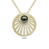 In this photo there is a yellow gold sun rays pendant with one dark green pearl and lined with diamonds.