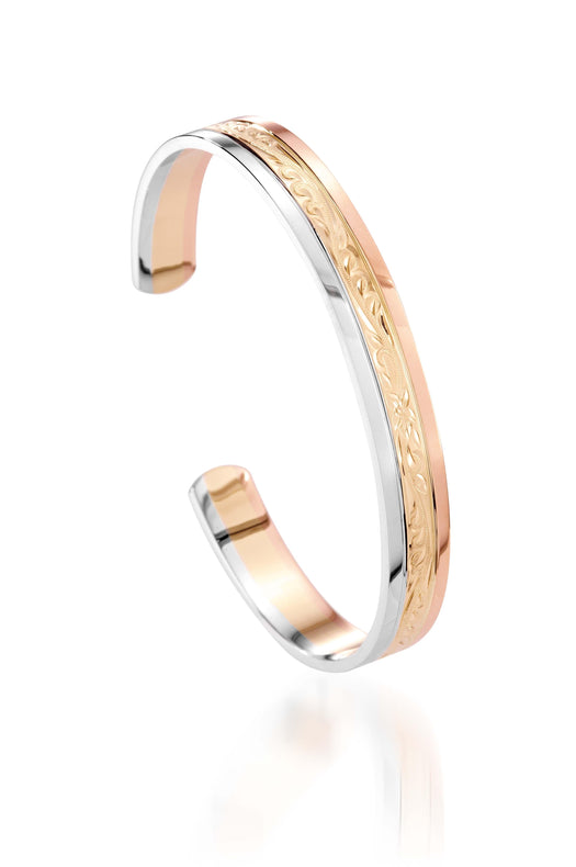The picture shows a 14K white, yellow, and rose gold tri-color bangle with plumeria engraving.