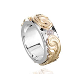 The picture shows a 14K white and yellow gold two-tone pinched 8 mm ring with hand-engravings and a diamond.