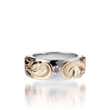 The picture shows a 14K white and yellow gold two-tone pinched 8 mm ring with hand-engravings and a diamond.