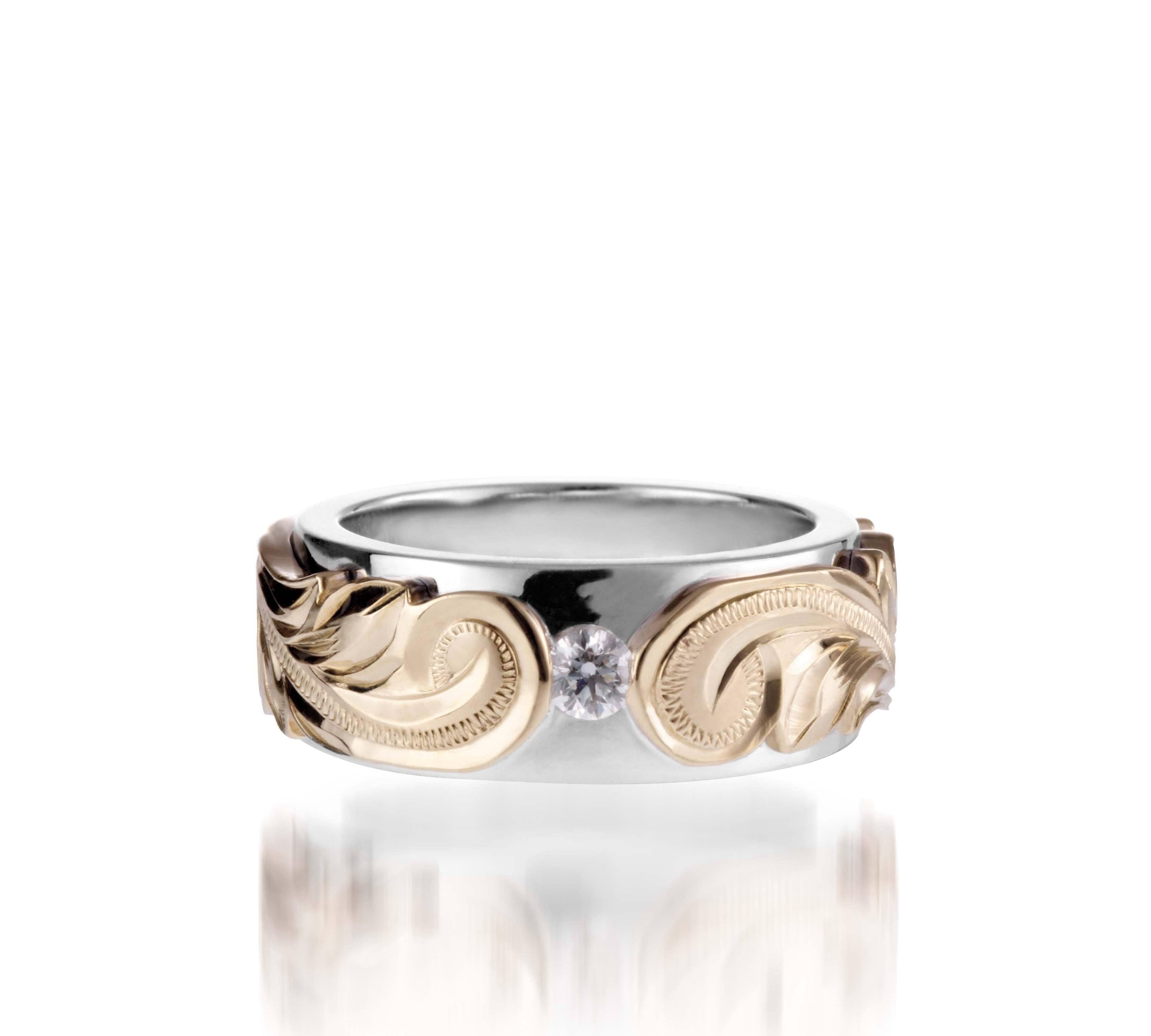 The picture shows a 14K white and yellow gold two-tone pinched 8 mm ring with hand-engravings and a diamond.