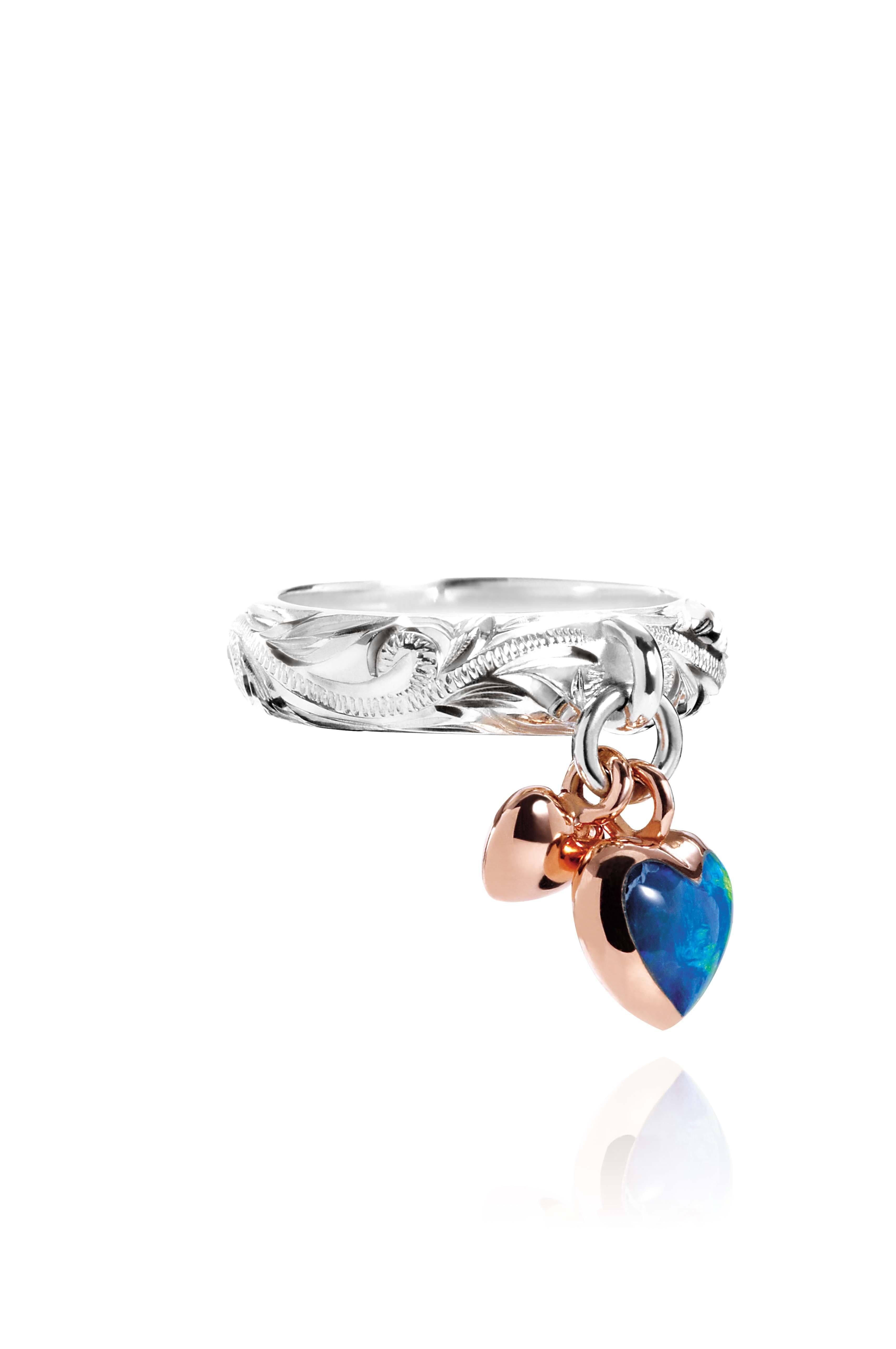 The picture shows a 14K rose gold and 925 sterling silver two-tone heart ring with hand engravings and opal.