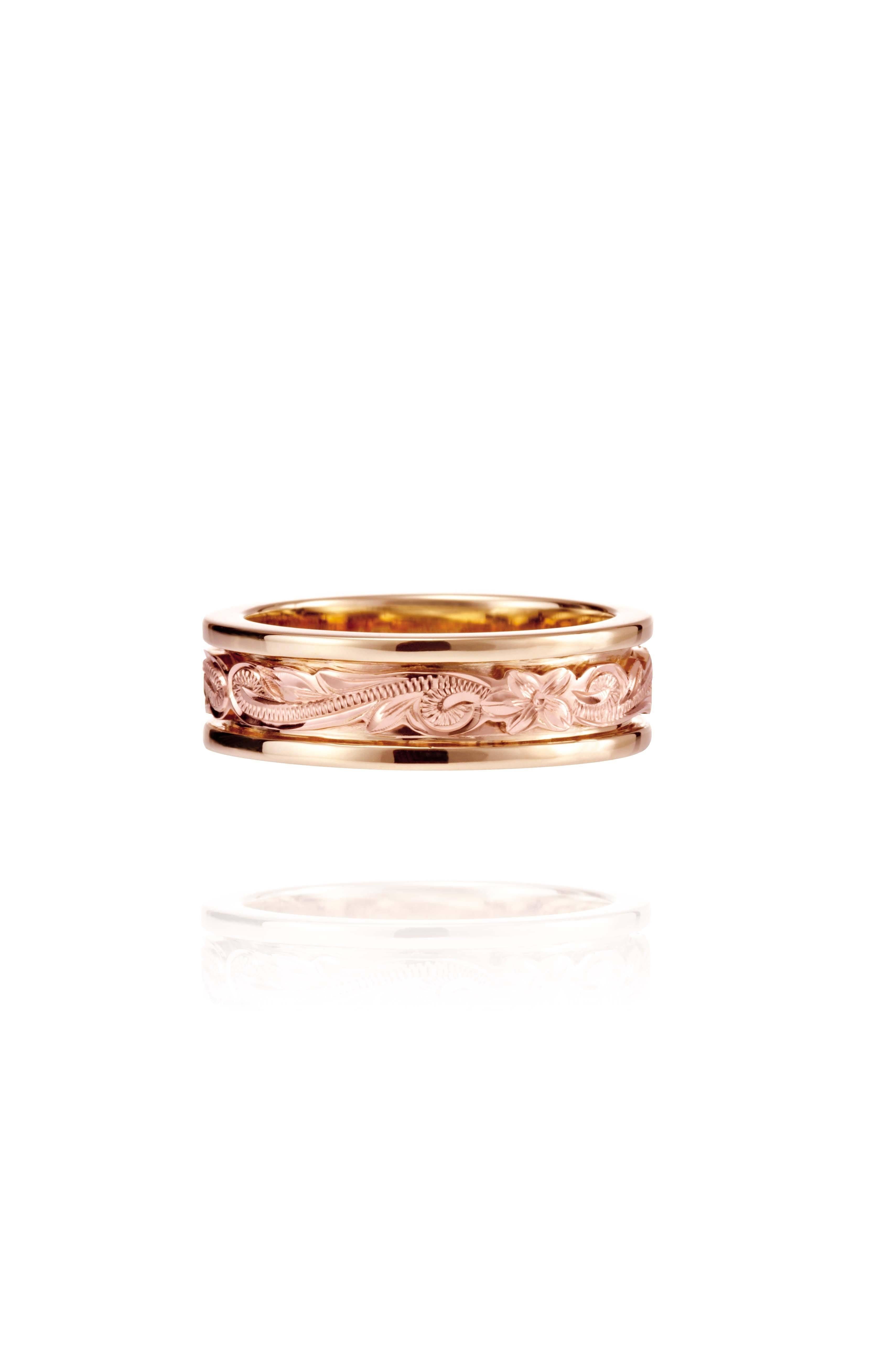 In this photo there is a yellow and rose gold two-tone ring with flower and scroll hand-engravings.