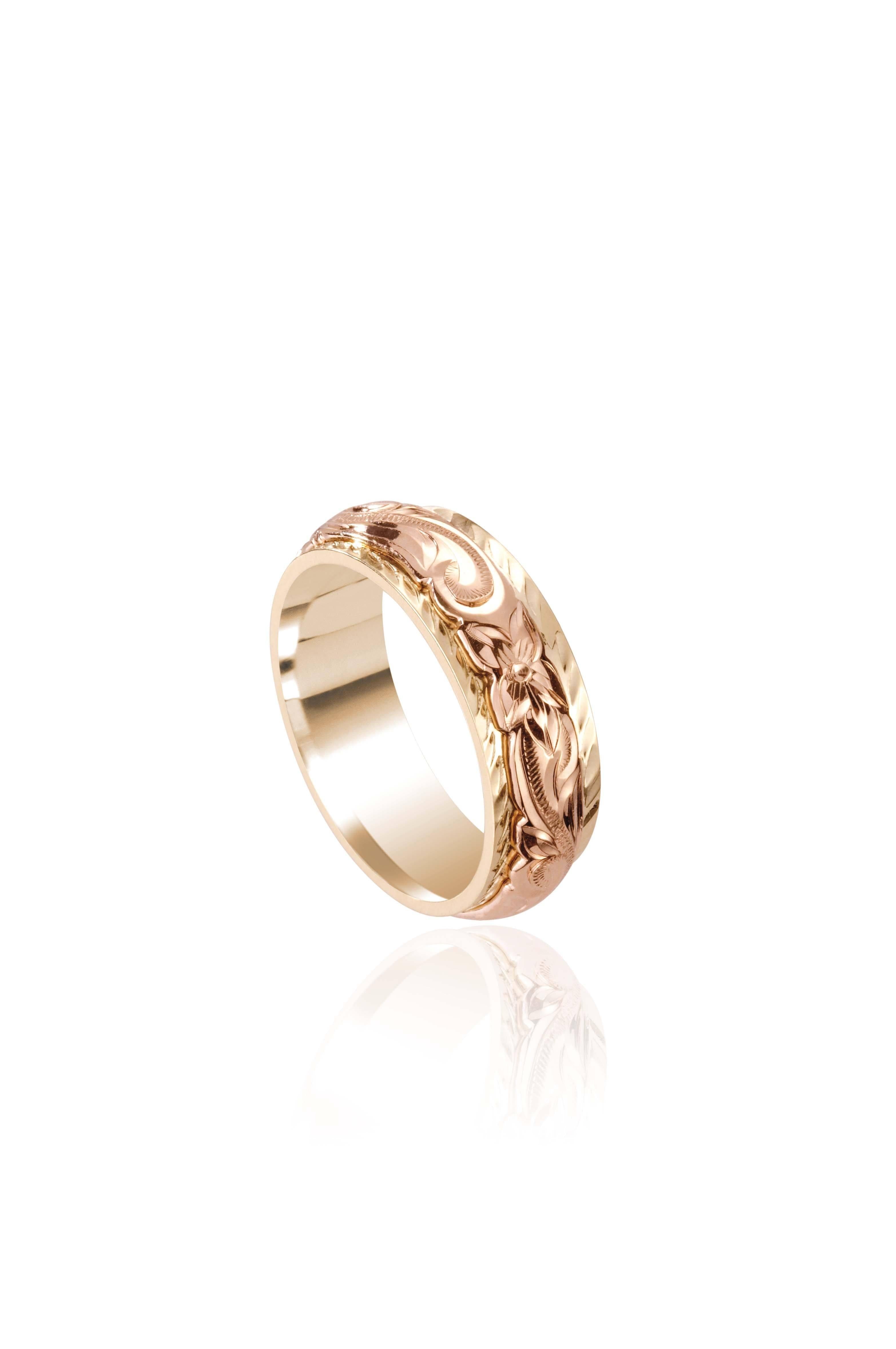 In this photo there is a rose and yellow gold two-tone ring with flower and scroll hand engravings.