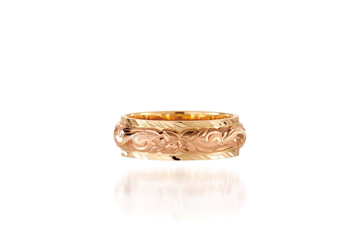In this photo there is a rose and yellow gold two-tone ring with flower and scroll hand engravings.