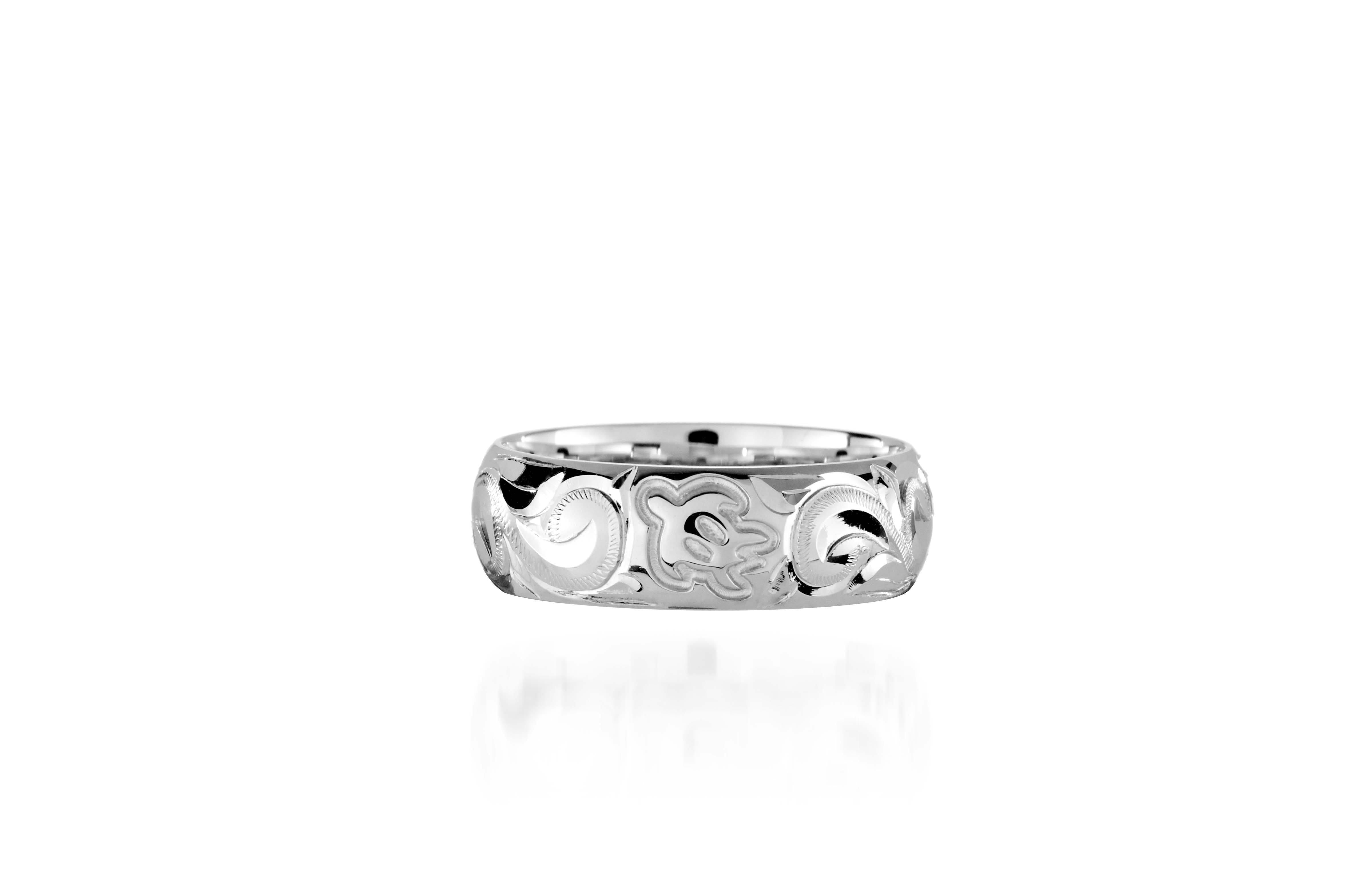 The picture shows a 18K white gold ring 6mm with hand-engravings including a sea turtle.