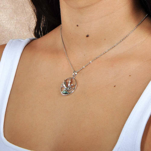 A model wearing the Sterling silver pendant designed to look like a Nene bird flying featuring Abalone.
