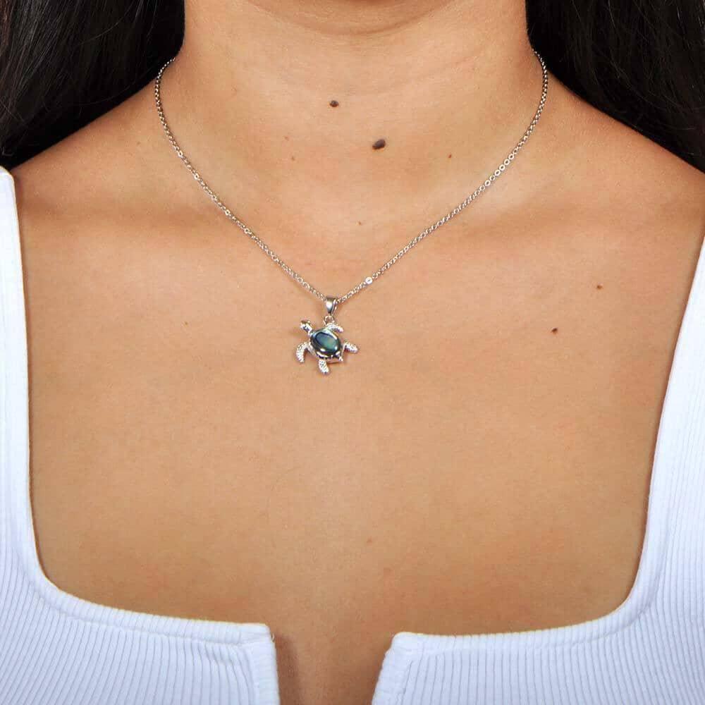 A model wearing a Sterling Silver Sea Turtle pendant, featuring and Abalone Shell. 