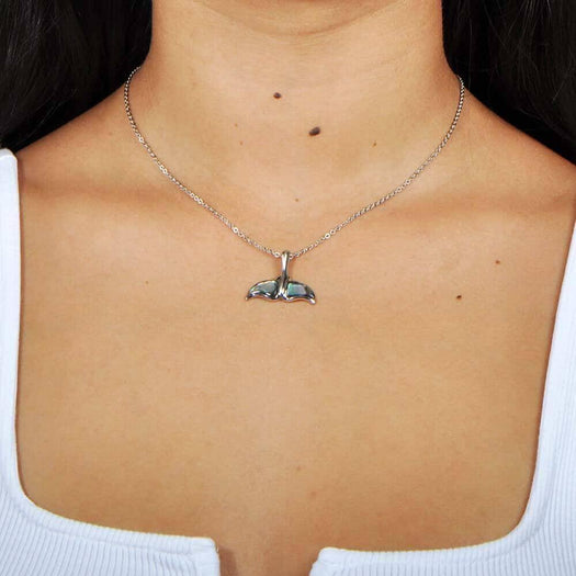 A model wearing a Sterling silver whale tail pendant featuring abalone. 