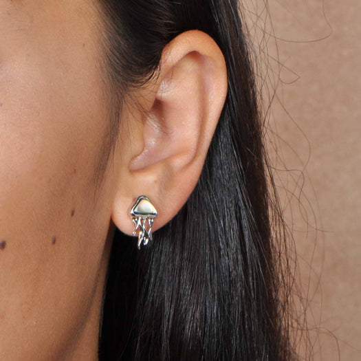 Sterling silver earing with an abalone gemstone shaped as jellyfish. The earrings are worn by a model.