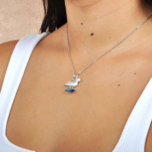 A model wearing a Sterling Silver Nene pendant featuring the bird stood on abalone.