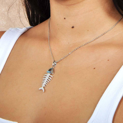 Sterling silver, abalone, and pave topaz fishbone pendant, worn by a model. 