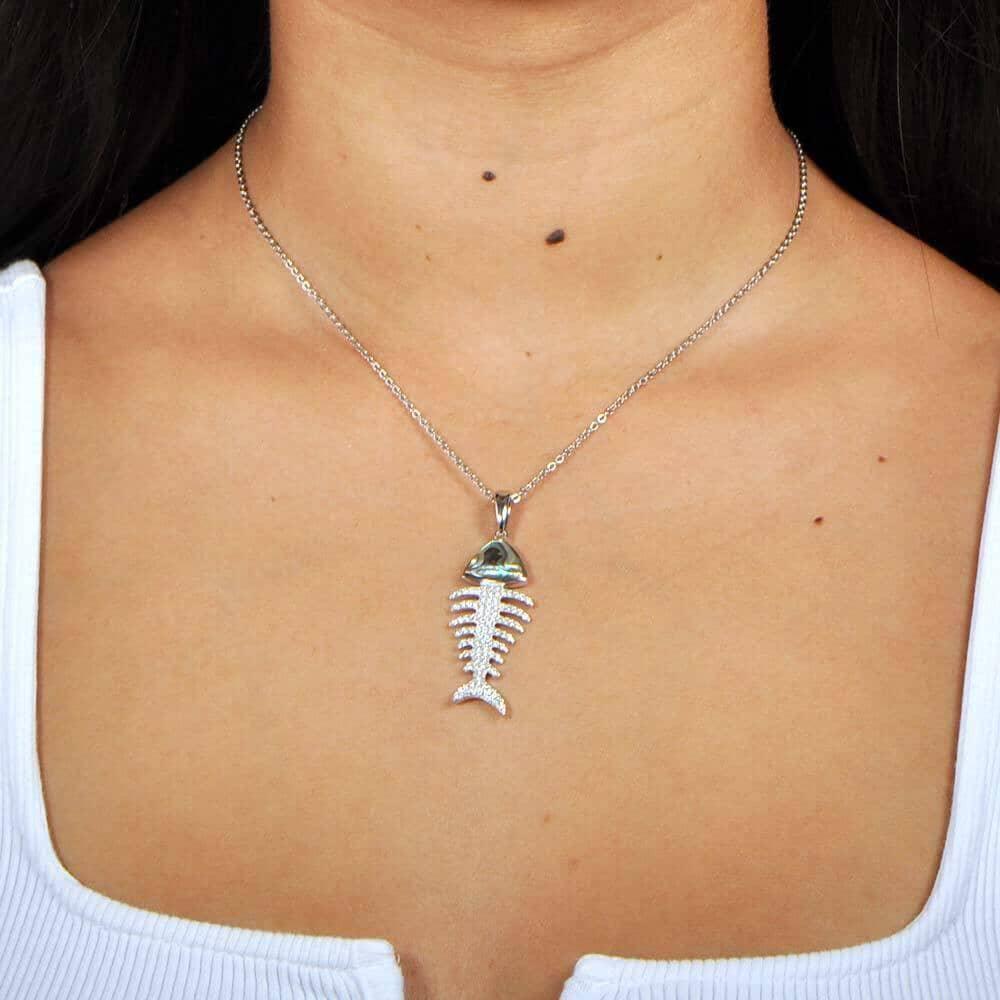 Abalone, pave, and sterling silver fishbone pendant worn by a model. 