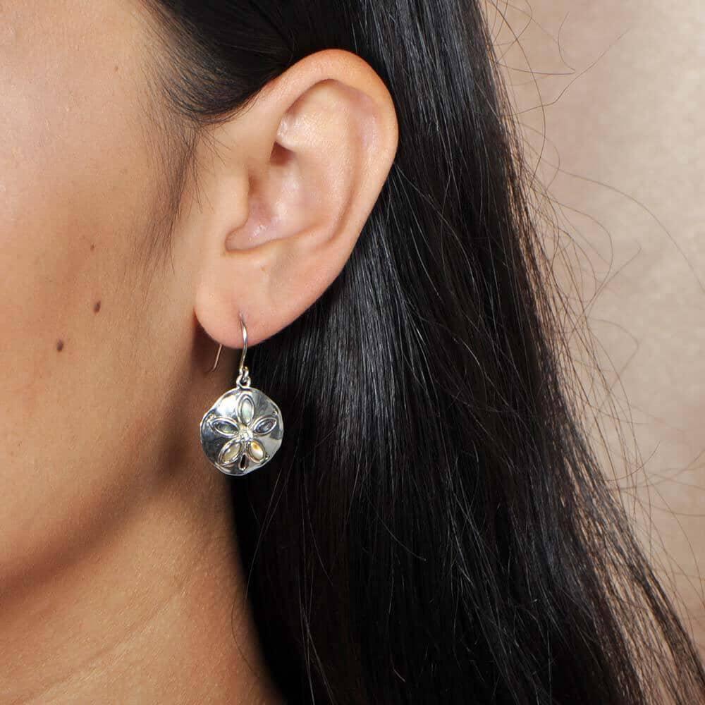 Sterling silver and Abalone sand dollar earrings worn by a model.