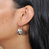 Sterling silver and Abalone sand dollar earrings worn by a model.