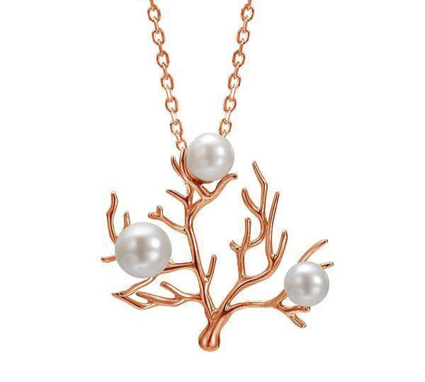 In this photo there is a small 14K rose gold coral pendant with three white pearls.