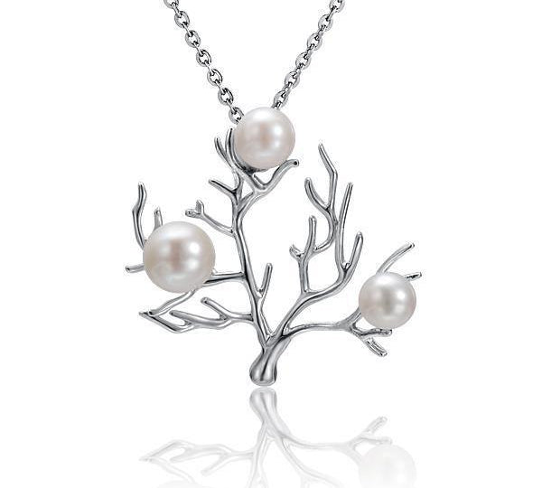 In this photo there is a small 14K white gold coral pendant with three white pearls.