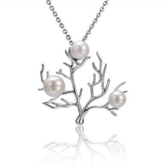 In this photo there is a small 14K white gold coral pendant with three white pearls.