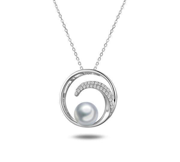 In this photo there is a white gold circle pendant with a wave, diamonds, and one white Akoya pearl.