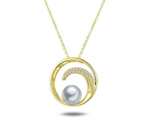 In this photo there is a yellow gold circle pendant with a wave, diamonds, and one white Akoya pearl.