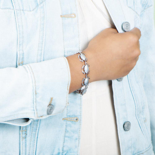 The picture shows a model wearing a  925 sterling silver white gold-plated blue crab bracelet.