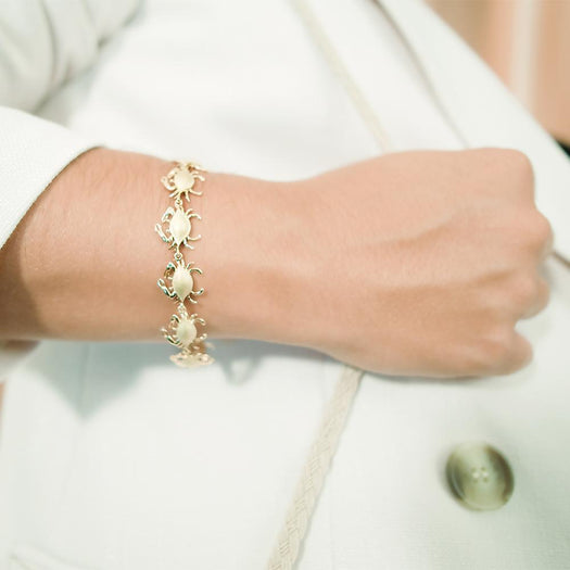 The picture shows a model wearing a 925 sterling silver yellow gold-plated blue crab bracelet.