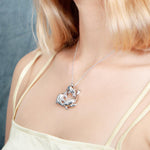 The picture shows a 925 sterling silver pendant featuring a circle of three dolphins with cubic zirconia.