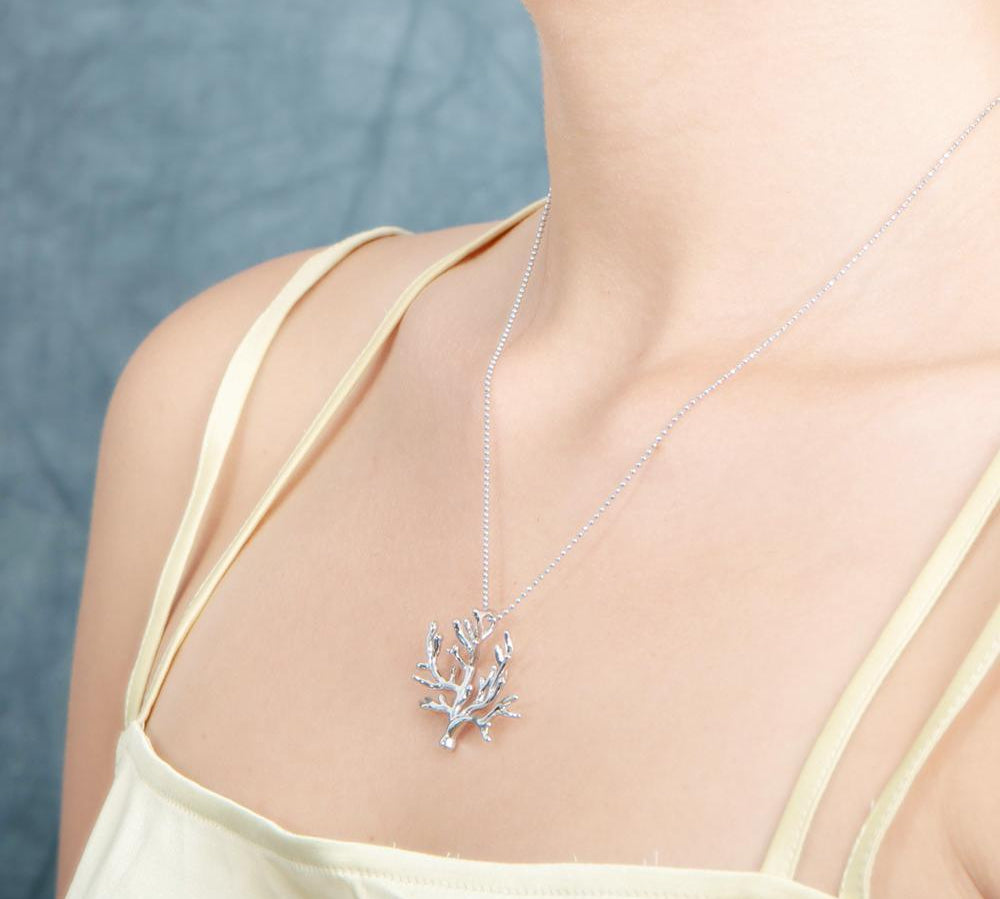 The picture shows a 925 sterling silver white gold vermeil coral pendant.