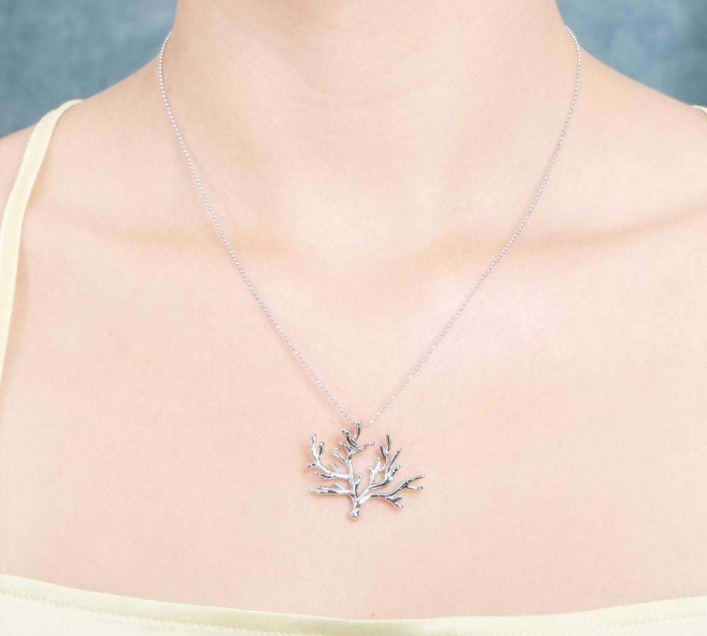 The picture shows a 925 sterling silver white gold vermeil coral pendant.