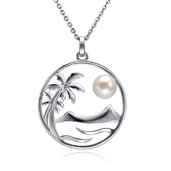 In this photo there is a white gold pendant with two palm trees, Diamond Head, and ocean waves placed within a circle, with one white pearl.