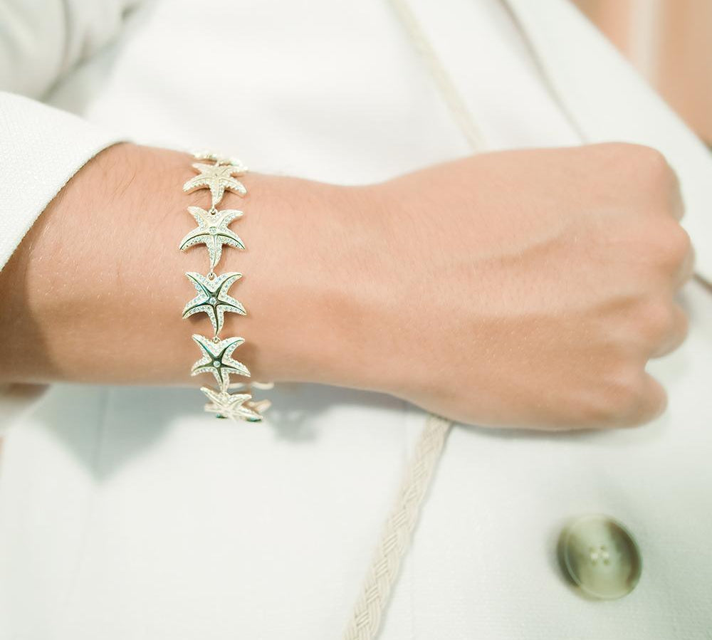 The picture shows a 925 sterling silver yellow gold-plated starfish bracelet with topaz.