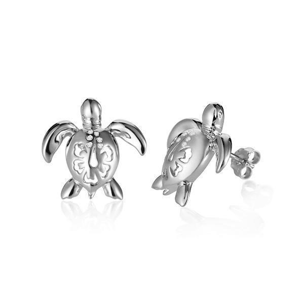 The picture shows a pair of 14K white gold sea turtle stud earrings with a hibiscus flower cut-out design and diamonds.
