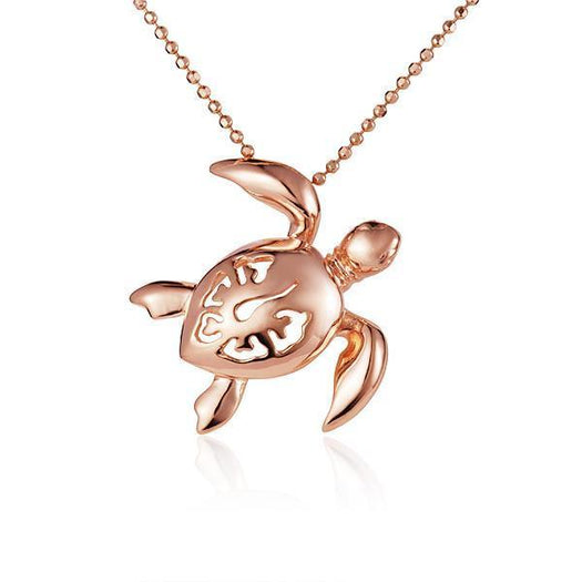 In this photo there is a rose gold sea turtle necklace with a hibiscus flower cut-out.