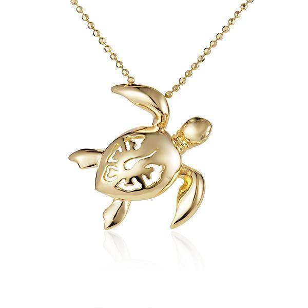 In this photo there is a yellow gold sea turtle necklace with a hibiscus flower cut-out.