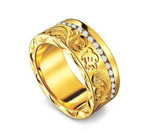 The picture shows a 14K yellow gold ring with hand engraved detailing and a sea turtle with a row of diamonds.