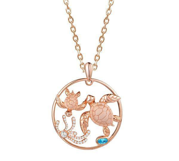 The picture shows a 14K rose gold circle pendant featuring two sea turtles, sea weed made of diamonds and  aquamarine.