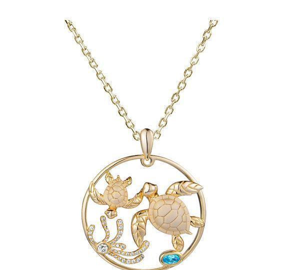 This picture shows a 14K yellow gold circle pendant featuring two sea turtles, sea weed of diamonds, and  aquamarine.