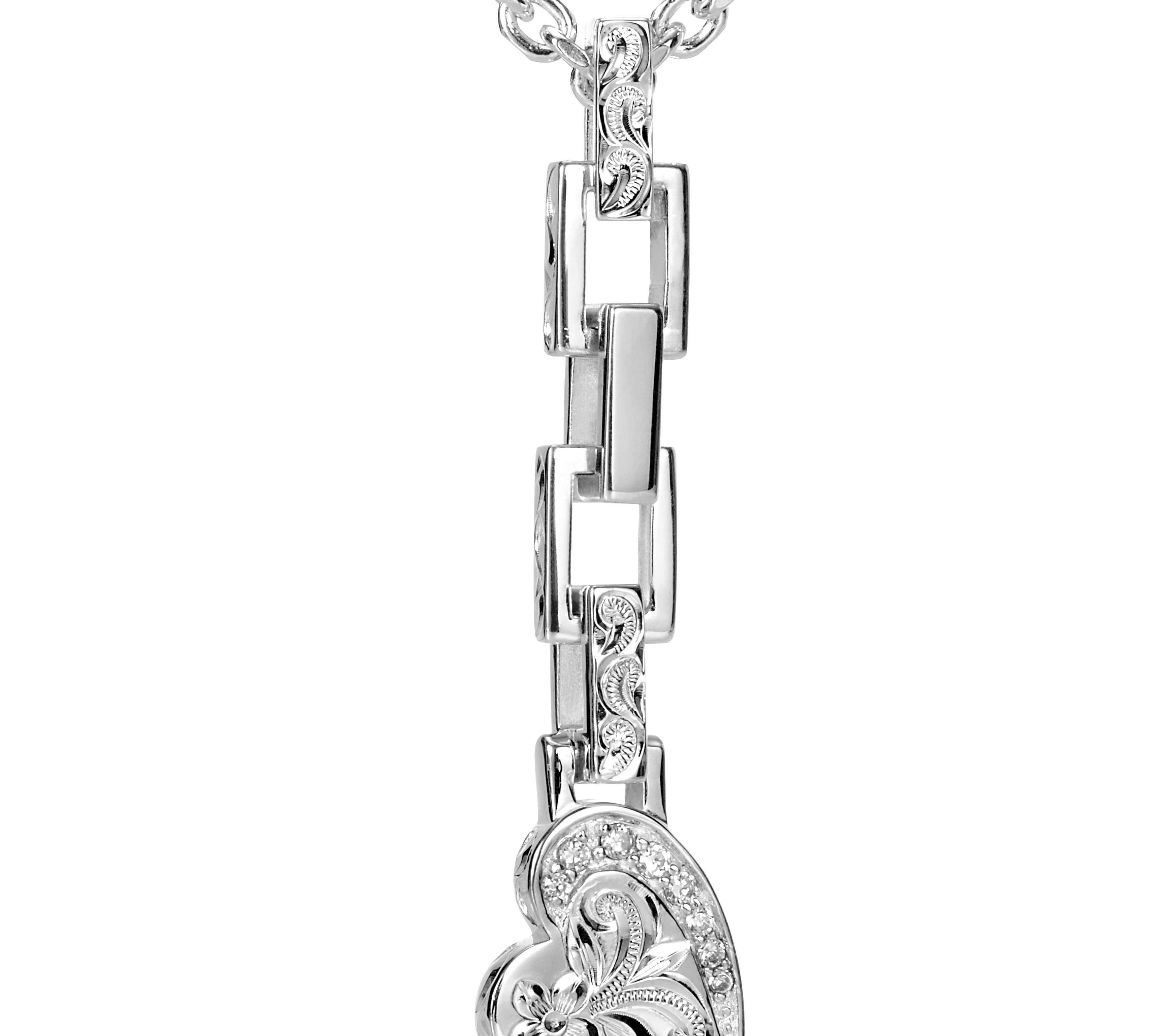 The picture shows a 925 sterling silver heart pendant with hand-engraved designs including a plumeria paired with topaz.