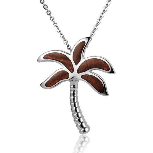 In this photo there is a large sterling silver and koa wood palm tree pendant.