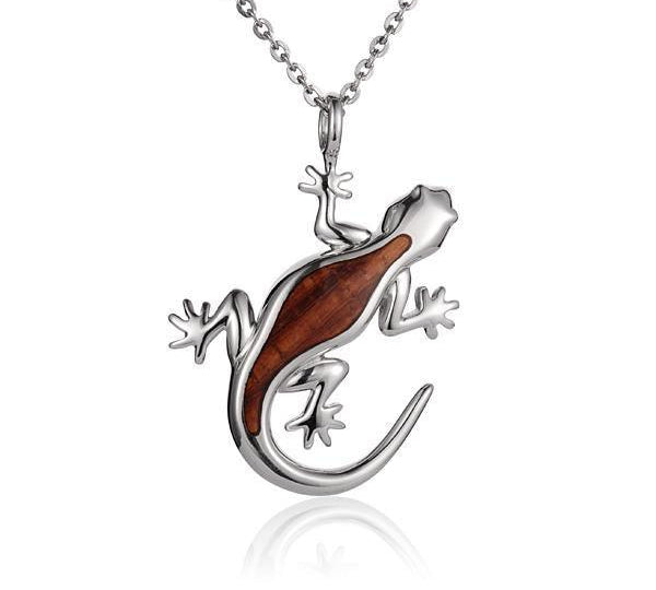 In this photo there is a sterling silver and koa wood gecko pendant.