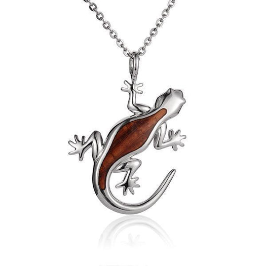 In this photo there is a sterling silver and koa wood gecko pendant.