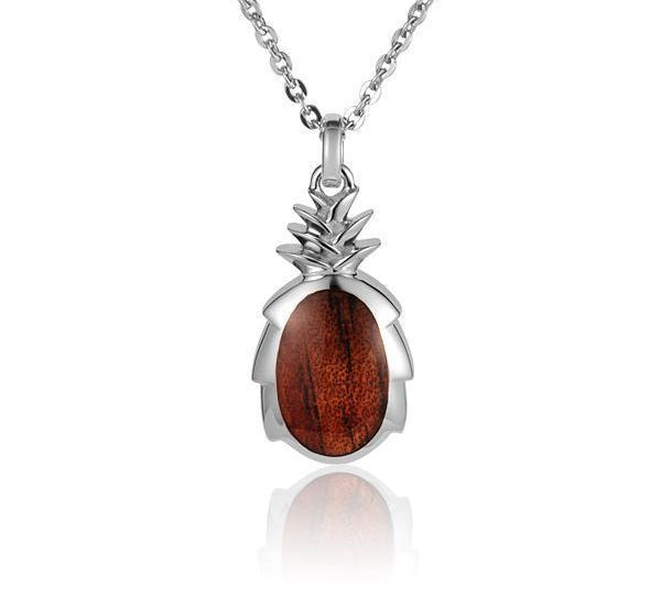 In this photo there is a small sterling silver and koa wood pineapple pendant.