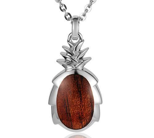 In this photo there is a large sterling silver and koa wood pineapple pendant.