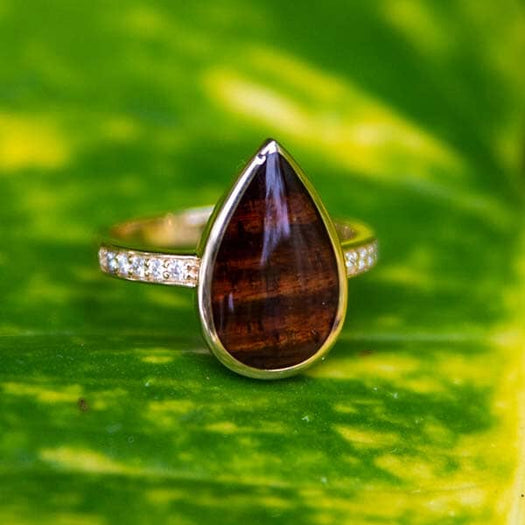 14k gold Koa wood tear drop ring with diamonds embedded in the band.
