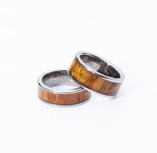 In this photo there are two rings made of koa wood and titanium.