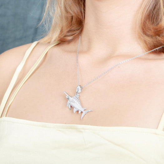 The picture shows a model wearing a 925 sterling silver marlin pendant.