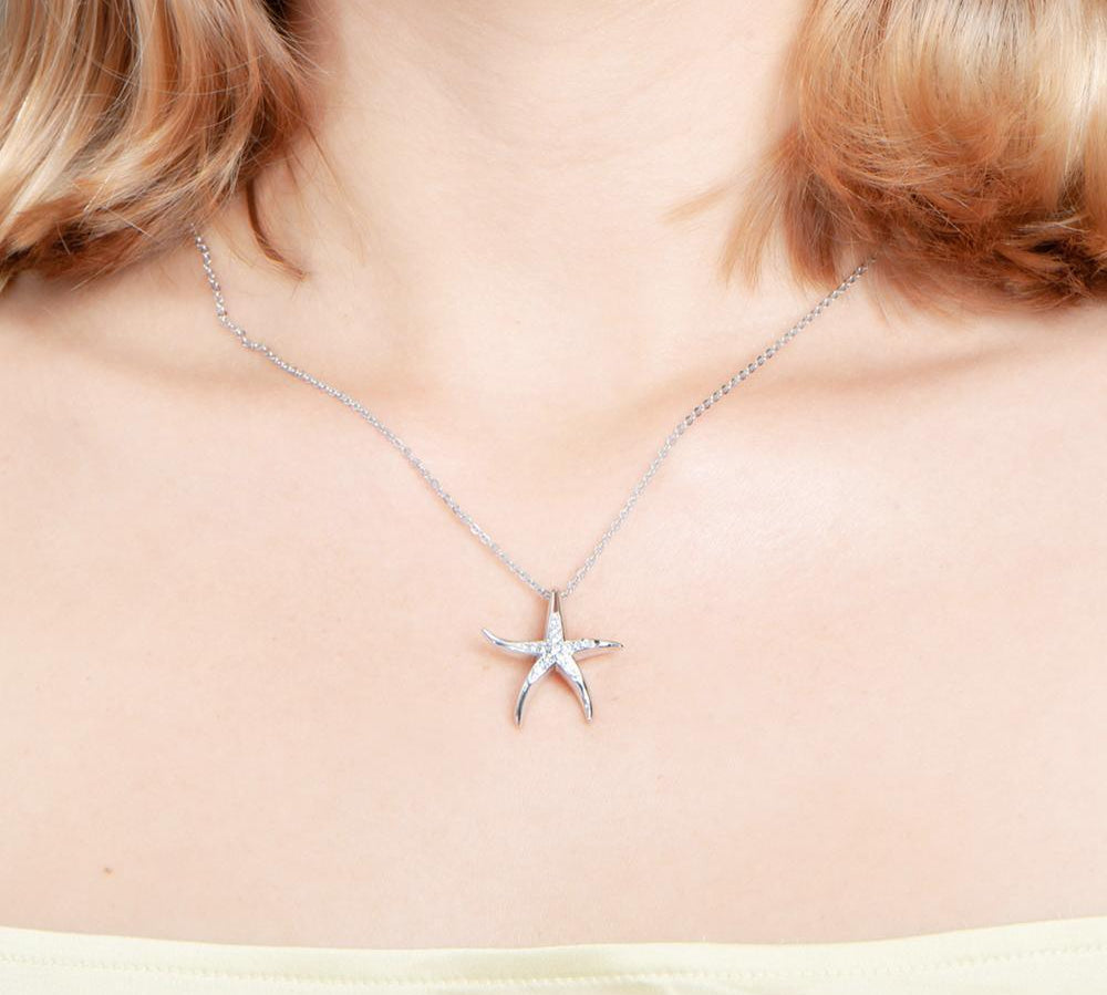 The picture shows a model wearing a 925 sterling silver starfish pendant with topaz.